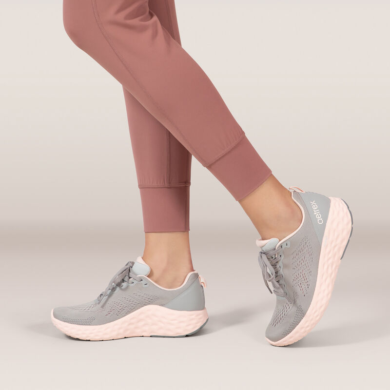 grey sneaker with pink sole on foot